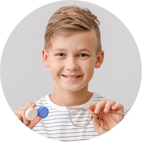 Young boy holding contact lenses case and eyeglasses
