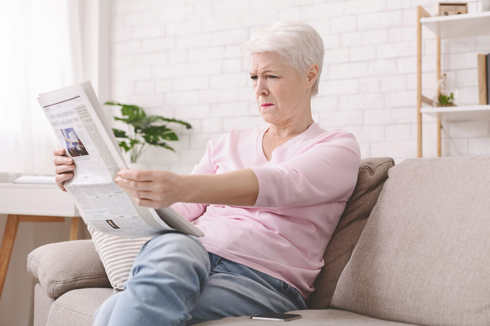 Woman reading news paper at Family Vision Optical