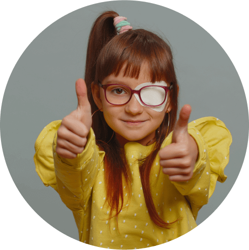 Young girl wearing glasses with eyepatch showing two thumbs up 