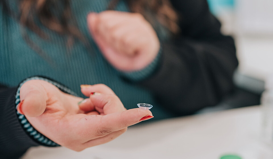 Woman fitting out a contact lens from Family Vision Optical